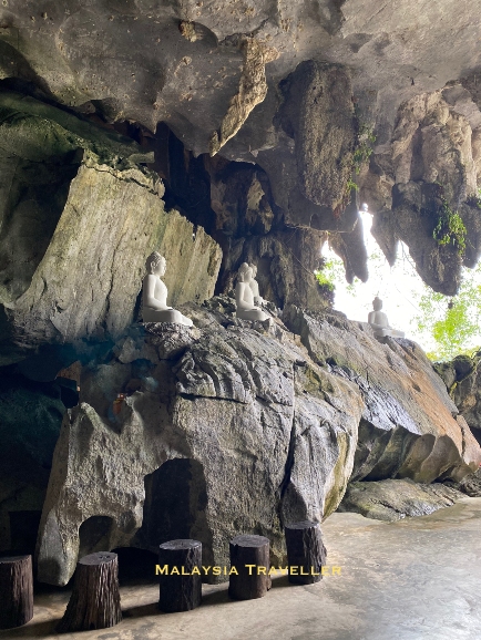 sitting buddha statues in a cave