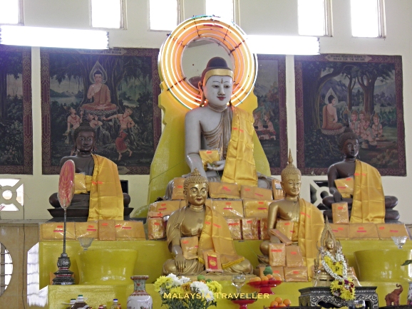 Buddhist statues with new clothing offerings Buddhist statues with new clothing offerings