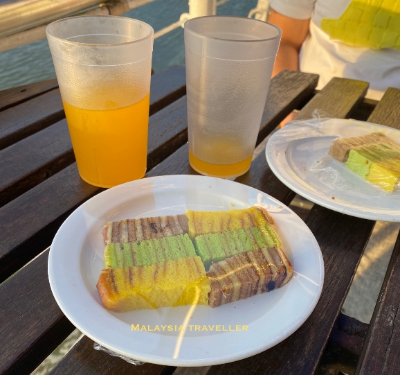 colourful local layer cake and orange drink colourful local layer cake and orange drink